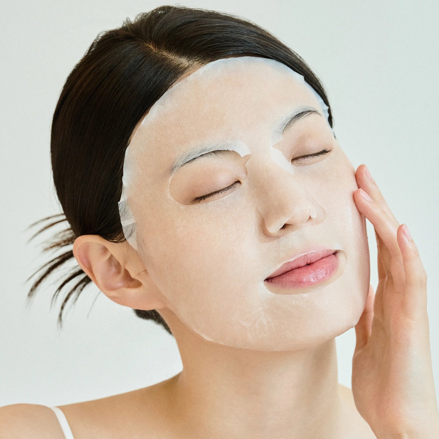 Applying SKIN1004 Tone Brightening Glow sheet mask to improve dull skin and enhance glow