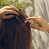 Aromatica Rosemary Root Enhancer being applied on scalp
