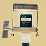 Dear Klairs Rich Moist Soothing Cream tube being squeezed with vintage wringer