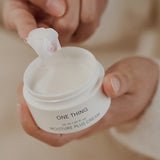 One Thing Moisture Plus Cream being scooped from jar by hand